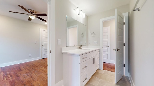 bathroom with wood finished floors, baseboards, ceiling fan, and vanity