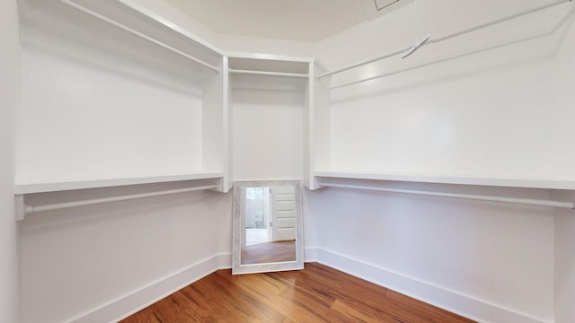 walk in closet with wood finished floors