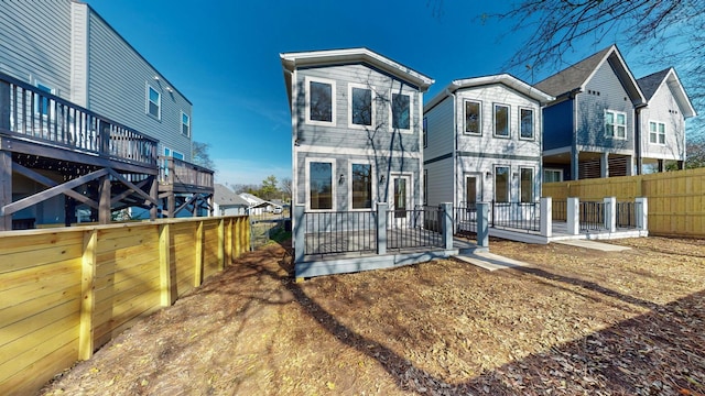 back of house with a wooden deck and fence