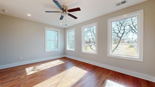 empty room with visible vents, baseboards, and wood finished floors