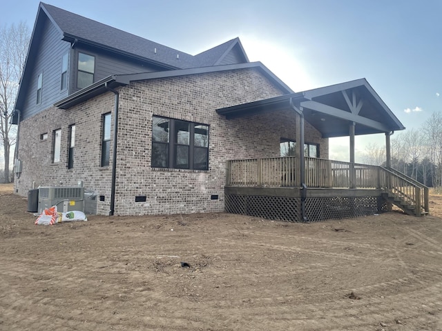 back of property with crawl space, brick siding, central AC unit, and a deck