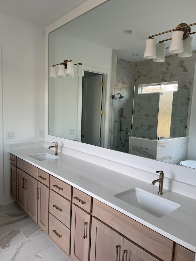 bathroom featuring double vanity, marble finish floor, a stall shower, and a sink