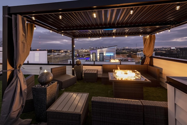 patio terrace at dusk with a view of city and an outdoor living space with a fire pit