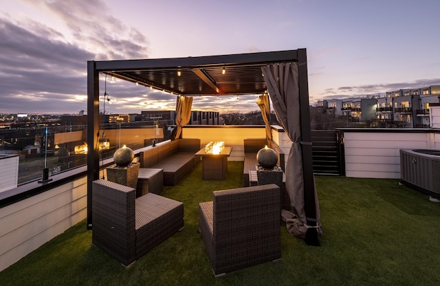 patio terrace at dusk with an outdoor living space with a fire pit, central AC unit, and a pergola