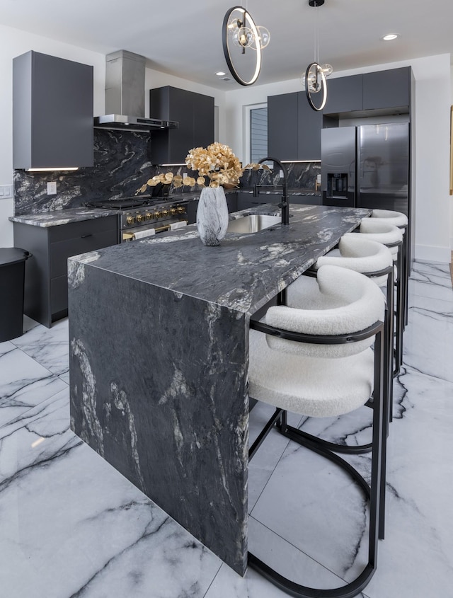 kitchen with marble finish floor, appliances with stainless steel finishes, modern cabinets, and wall chimney range hood