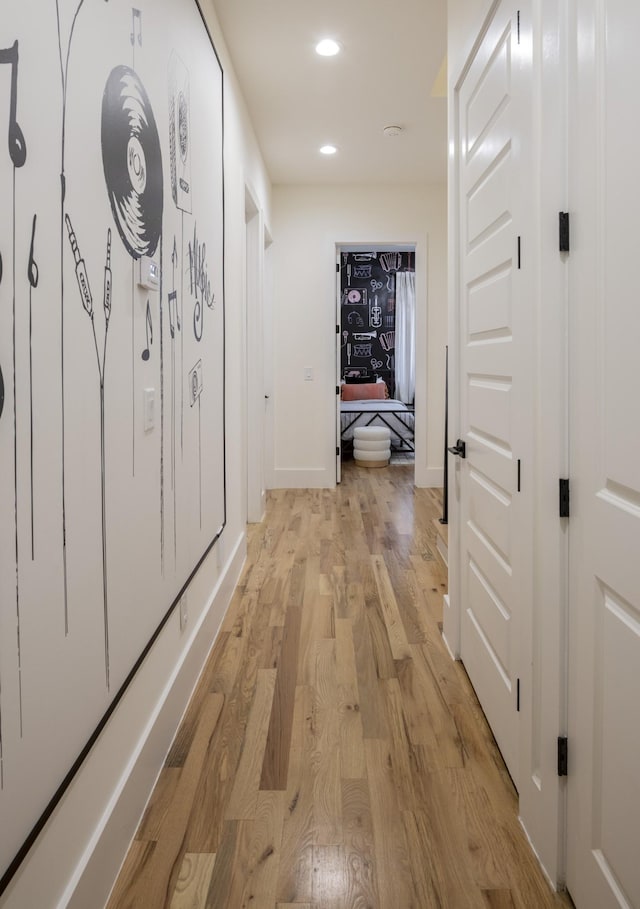 hallway featuring recessed lighting, baseboards, and light wood-style floors