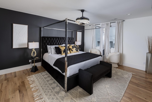 bedroom with baseboards and wood finished floors