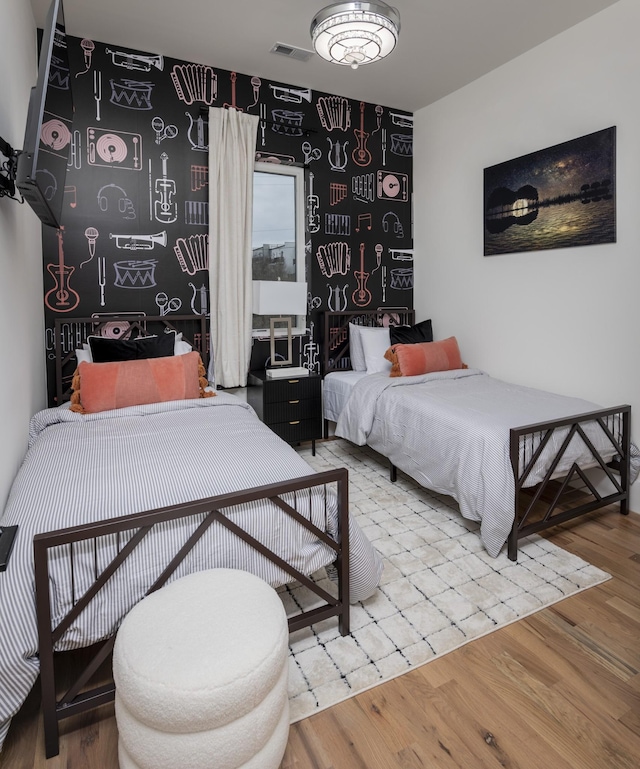 bedroom featuring visible vents and wood finished floors