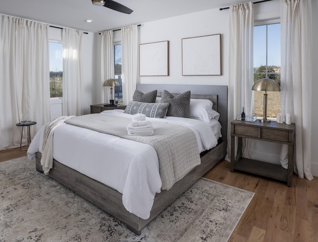 bedroom with ceiling fan, multiple windows, wood finished floors, and recessed lighting