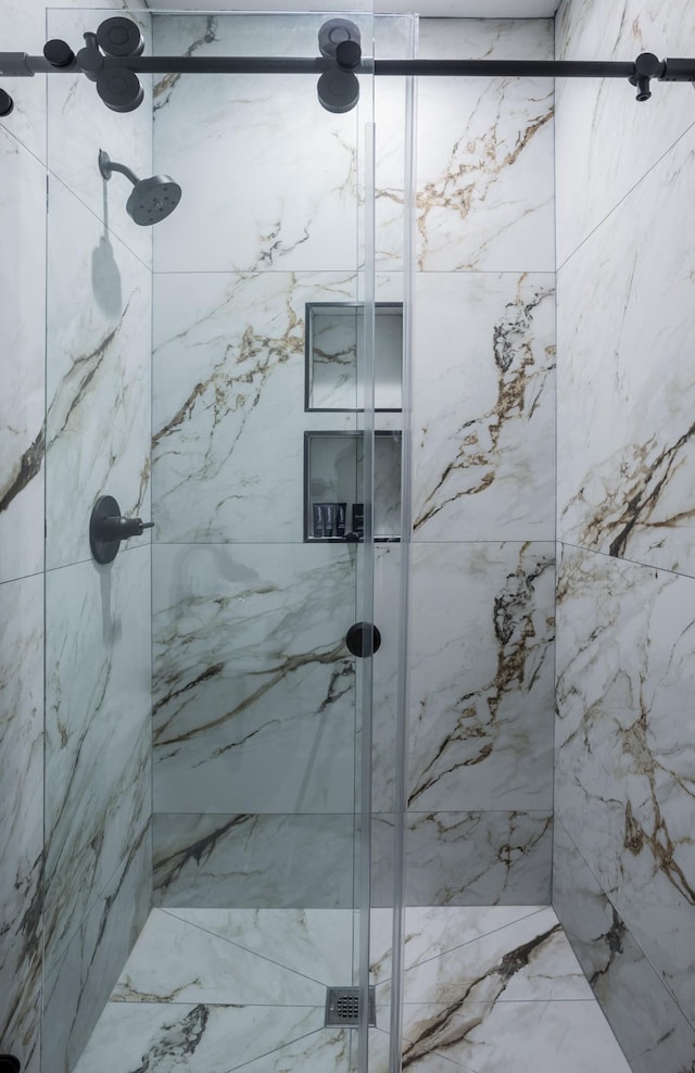 bathroom featuring a marble finish shower