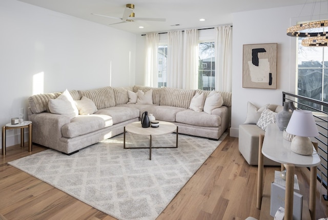 living room featuring recessed lighting, ceiling fan with notable chandelier, and wood finished floors