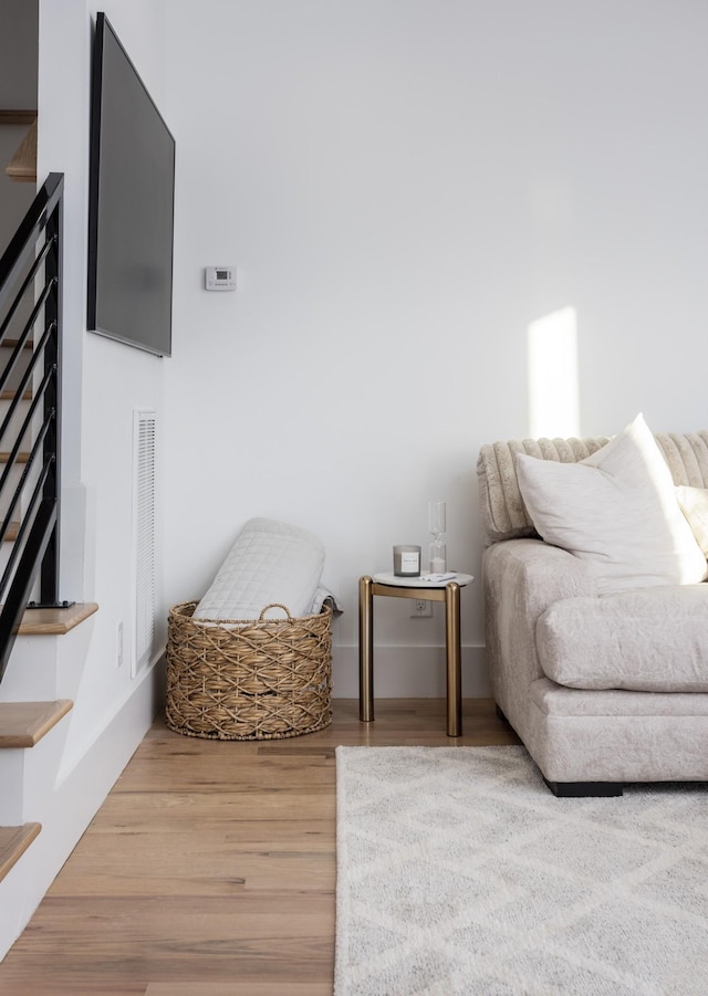 living area with visible vents and wood finished floors