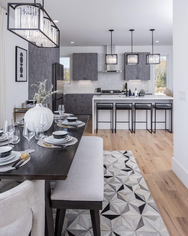 dining space with a notable chandelier and light wood-style flooring