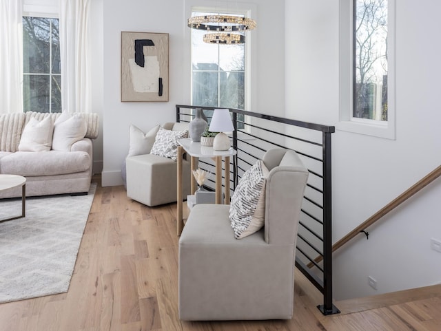 living room featuring an inviting chandelier, wood finished floors, and baseboards