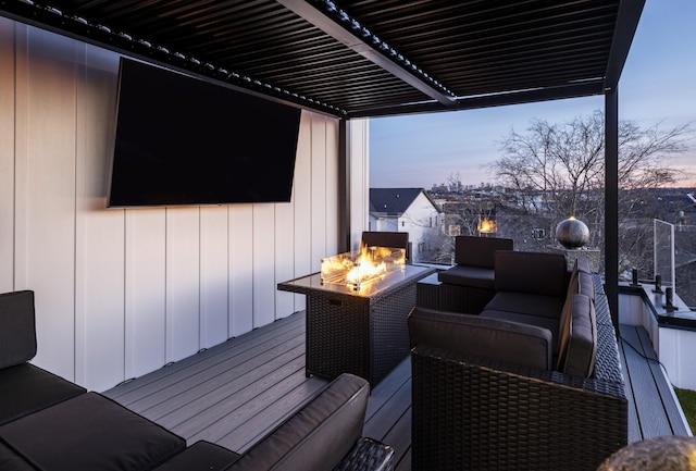 deck at dusk featuring a fire pit