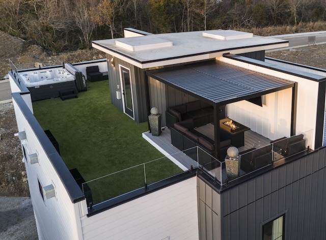 view of side of home featuring a jacuzzi and a lawn