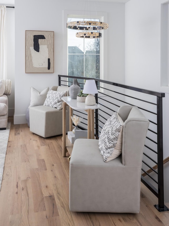 living area with a chandelier, baseboards, and wood finished floors