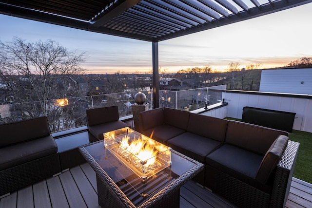 deck at dusk featuring an outdoor living space with a fire pit and a pergola