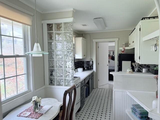 kitchen with plenty of natural light, backsplash, white cabinetry, and light countertops