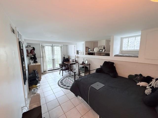 bedroom featuring visible vents, multiple windows, and light tile patterned flooring