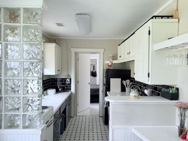 kitchen with visible vents, light countertops, decorative backsplash, white cabinets, and white electric stove