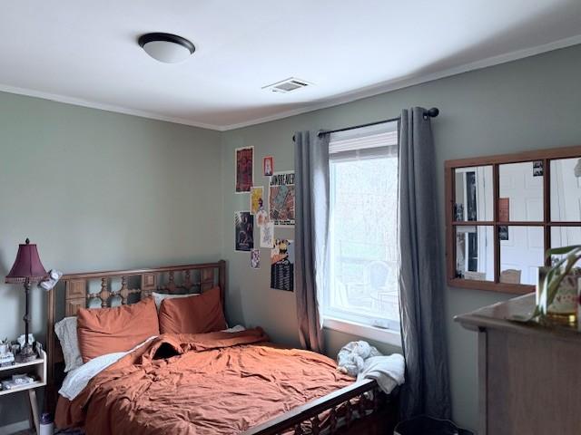 bedroom with crown molding and visible vents