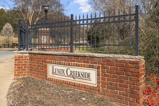 community / neighborhood sign featuring fence