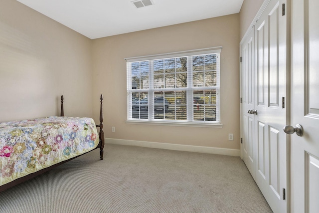 bedroom with visible vents, baseboards, and light colored carpet