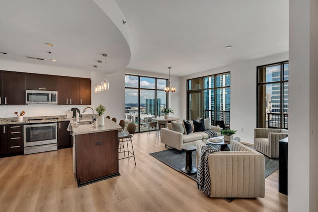 kitchen with a breakfast bar area, a notable chandelier, open floor plan, and stainless steel appliances