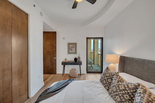 bedroom featuring baseboards, light wood finished floors, and ceiling fan