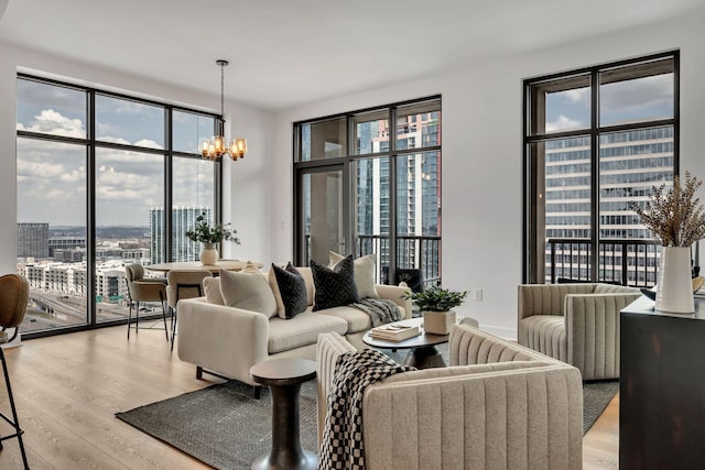 living area with a city view, an inviting chandelier, and light wood finished floors