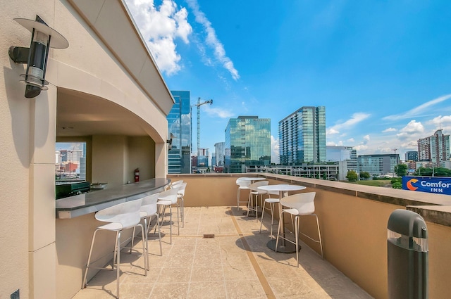 view of patio / terrace featuring an outdoor bar and a city view