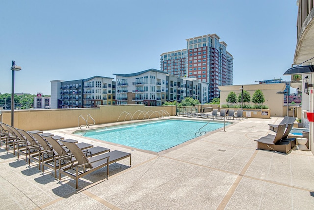 community pool with a city view and a patio