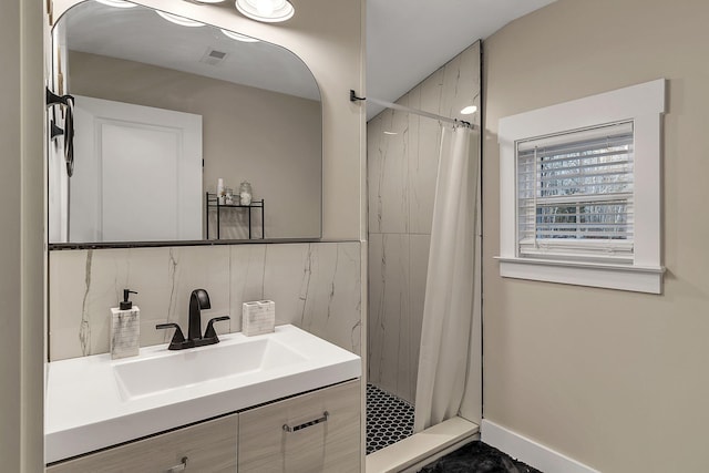 bathroom featuring visible vents, a shower stall, vanity, and baseboards