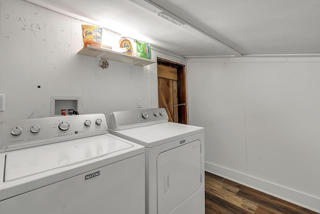 clothes washing area with laundry area, washing machine and dryer, dark wood-style flooring, and baseboards