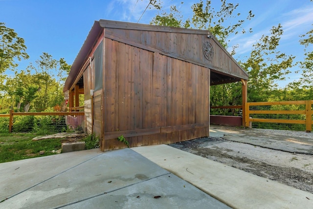 view of outbuilding featuring fence