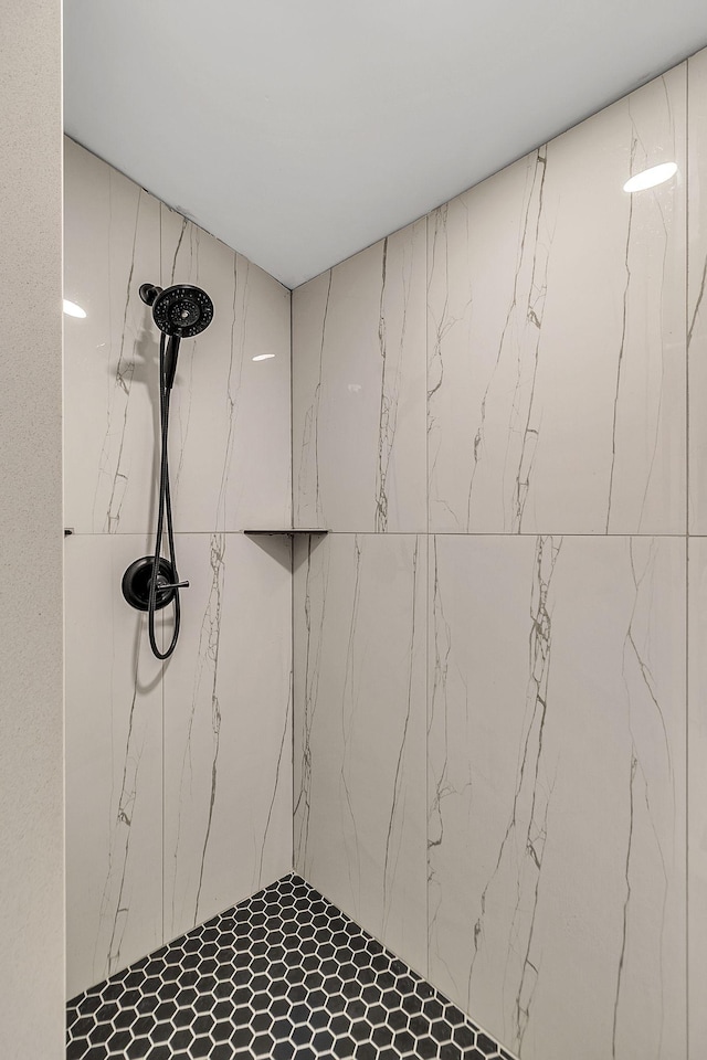 bathroom featuring a marble finish shower