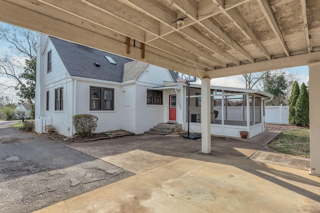 exterior space featuring fence, entry steps, and a sunroom