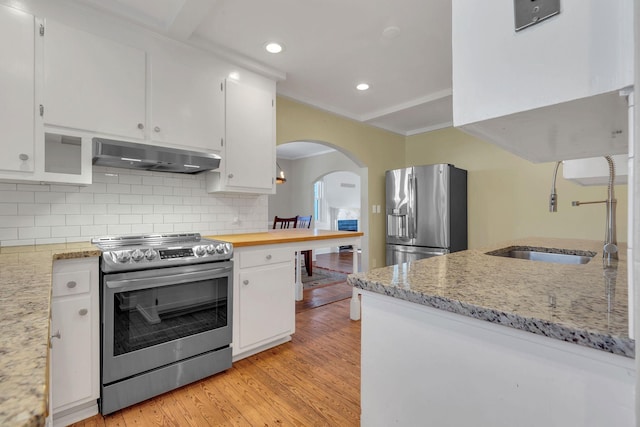 kitchen featuring a sink, under cabinet range hood, appliances with stainless steel finishes, white cabinetry, and light wood-type flooring