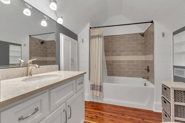 bathroom with shower / bath combo with shower curtain, lofted ceiling, wood finished floors, and vanity