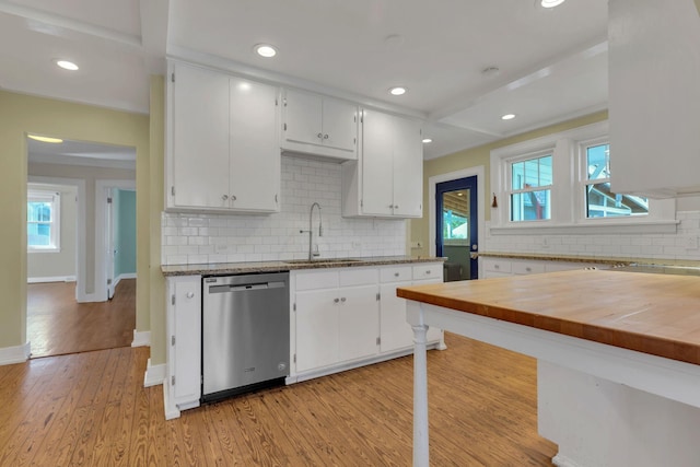 kitchen with baseboards, dishwasher, light wood-style floors, white cabinets, and a sink