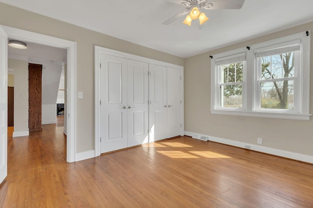 unfurnished bedroom with visible vents, baseboards, a ceiling fan, and light wood finished floors