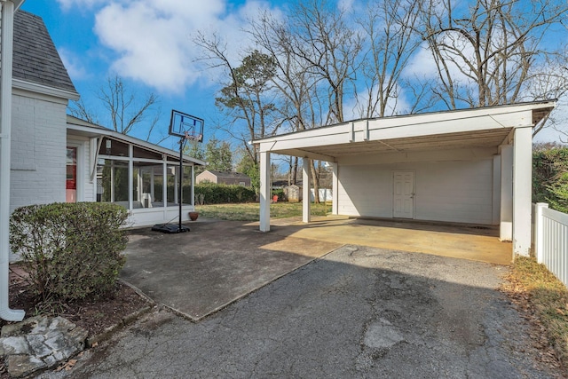 exterior space with fence, driveway, and a sunroom