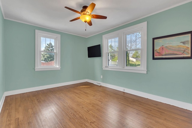 unfurnished room with visible vents, wood finished floors, crown molding, baseboards, and ceiling fan