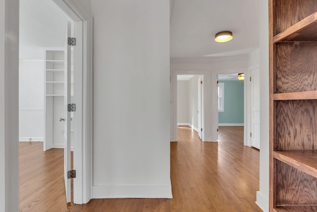 hallway featuring baseboards and wood finished floors