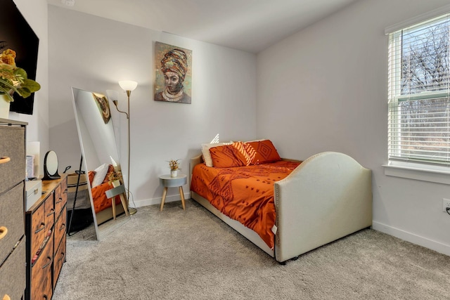 bedroom with light colored carpet and baseboards