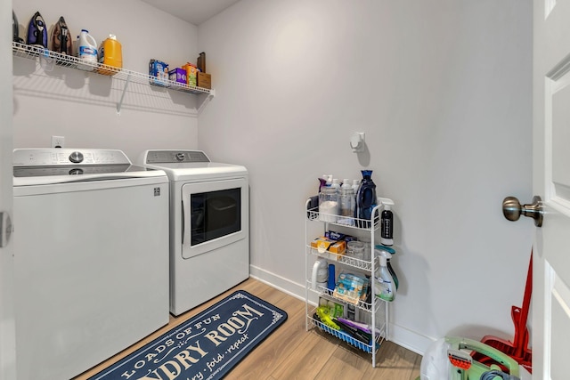 laundry area featuring washer and clothes dryer, laundry area, baseboards, and wood finished floors