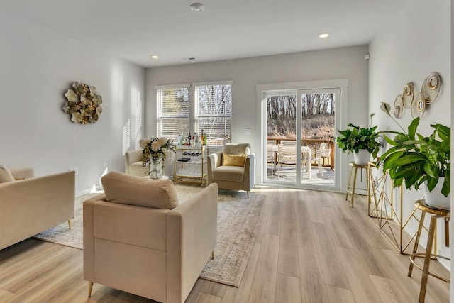 living area with recessed lighting and light wood-style floors