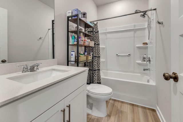 bathroom with vanity, toilet, wood finished floors, and shower / bath combo