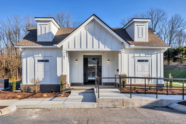 view of front of house featuring board and batten siding and roof with shingles